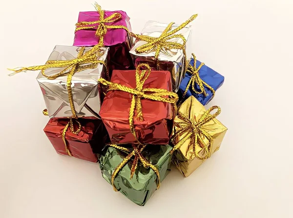 许多礼物的特写 这些礼物用漂亮的纸包着 用不同颜色的缎带系在白色的背景上 说明1 — 图库照片