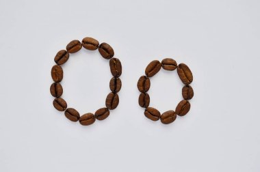 Beyaz arka planda kahve çekirdeklerinden yapılmış harfler..