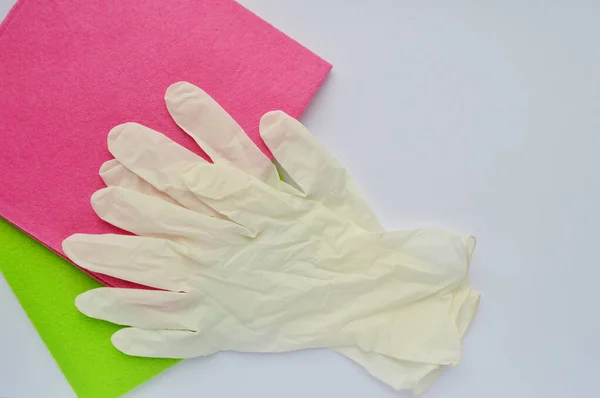 Cleaning rag in various colors and white rubber gloves on white background. Towels day