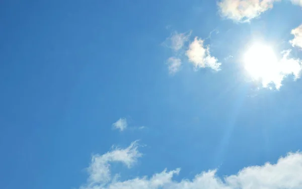 Mavi gökyüzündeki güneş. Beyaz bulutlu mavi gökyüzü arkaplanı. Uluslararası iklim günü. Dünya meteoroloji günü. Dünya Rüzgâr Günü