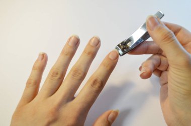 Tırnak makasıyla el manikürü. Beyaz arkaplanı kapatın. Evdeki kaplıca