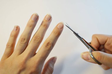 Tırnak makası ile el manikürü. Beyaz arkaplanı kapatın. Evdeki kaplıca