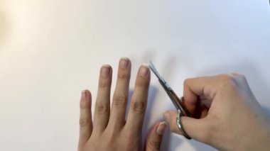 Tırnak makası ile el manikürü. Beyaz arkaplanı kapatın. Evdeki kaplıca.
