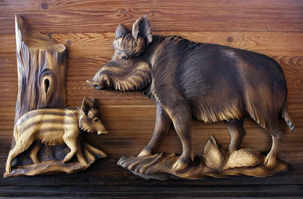 A wooden mural carved in a tree by the boar. Wood carving as an art.