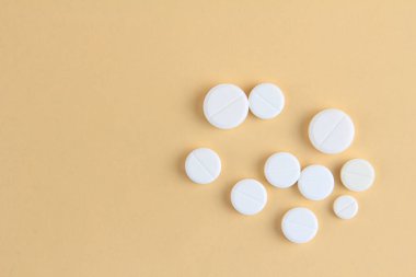 Tıp konsepti. Bej arka planda çeşitli tabletler ve ilaçlar var. Tablet kavramı. İlaç almak için. Kopyalama alanı