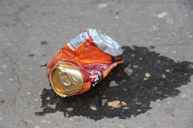 Buruşmuş teneke kutu yerde yatıyor.