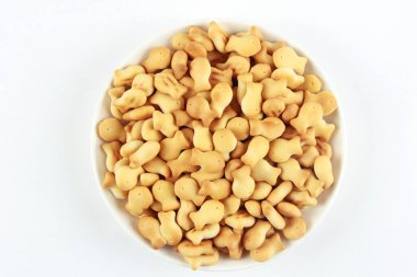 Beyaz arka planda beyaz bir tabakta balık şeklinde lezzetli kurabiyeler.