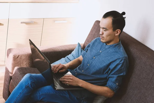 在家里沙发上的笔记本电脑上工作的亚洲人 教育和商业 自由职业者 — 图库照片