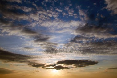 Akşamları Cirrus bulutlarıyla mavi gökyüzünde parlak, güzel bir gün batımı. Doğa ve hava tahmini