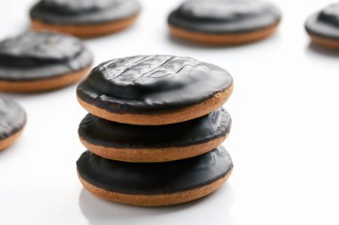 Yuvarlak bir pofuduk çikolatalı kurabiyenin beyaz bir arka planı var. Yan görünüm