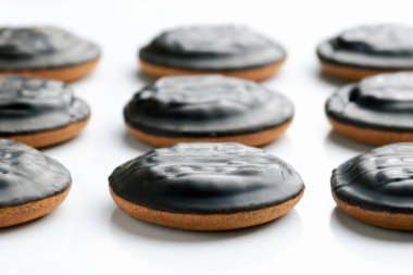 Beyaz arka planda çikolata kaplı yuvarlak ev yapımı kurabiyelerin yan görüntüsü. Tatlılar ve kahvaltı hamur işleri hazırlama kavramı