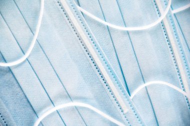 Mavi arka plandaki koruyucu tıbbi yüz maskelerinin dokusuna yakından bakın. Viral enfeksiyon salgını sırasında güvenlik ve önleme kavramı COVID-19