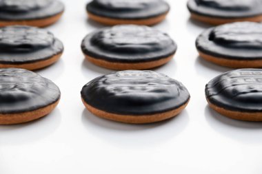 Beyaz arka planda çikolata kaplı yuvarlak ev yapımı kurabiyelerin yan görüntüsü. Tatlılar ve kahvaltı hamur işleri hazırlama kavramı