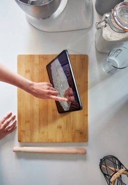 Evde Mutfakta Dijital Tablet Üzerinde Dokunmatik Ekran Kullanan Kadın Kesme Tahtasında