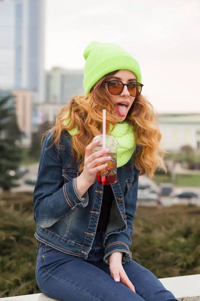 サングラス、幸せな若い女光緑の帽子とスカーフ、屋外でカクテルを飲む — ストック写真