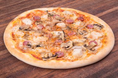 Sıcak pizza dilimi, erimiş peynirle ahşap bir masada.