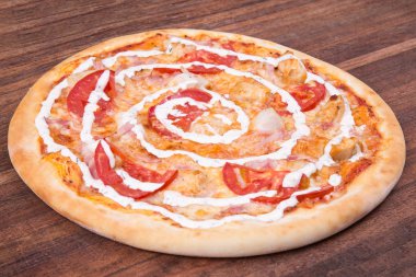Sıcak pizza dilimi, erimiş peynirle ahşap bir masada.