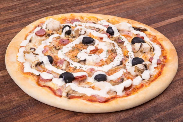 Sıcak pizza dilimi, erimiş peynirle ahşap bir masada.