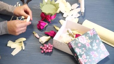 Oluklu kağıt kesmek parlak pembe kadın elinde close-up. Kağıt origami çiçek düğmesinin kadın dekoratör pas geçiyor. Modern Sanat: partiler, Düğünler ve 8 Mart süslemek için kağıt el sanatları yapma