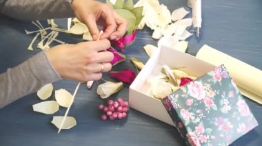 Oluklu kağıt kesmek parlak pembe kadın elinde close-up. Kağıt origami çiçek düğmesinin kadın dekoratör pas geçiyor. Modern Sanat: partiler, Düğünler ve 8 Mart süslemek için kağıt el sanatları yapma
