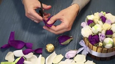 Oluklu kağıt kesmek parlak pembe kadın elinde close-up. Kağıt origami çiçek düğmesinin kadın dekoratör pas geçiyor. Modern Sanat: partiler, Düğünler ve 8 Mart süslemek için kağıt el sanatları yapma