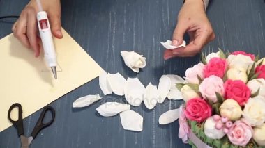 Oluklu kağıt kesmek parlak pembe kadın elinde close-up. Kağıt origami çiçek düğmesinin kadın dekoratör pas geçiyor. Modern Sanat: partiler, Düğünler ve 8 Mart süslemek için kağıt el sanatları yapma