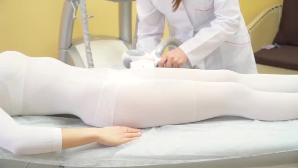 Femme est dans le processus à la clinique lipomassage.LPG massage dans le centre de beauté.Femme couchée sur le lit dans un salon de spa et recevant la procédure de massage lipo. — Video