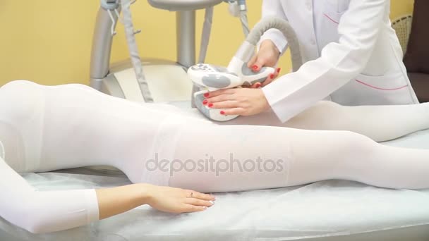 Жінка знаходиться в процесі в клініці ліпомасажу. ЛПГ масаж в центрі краси. Жінка лежить на ліжку в спа-салоні і приймає процедуру масажу ліпо. — стокове відео