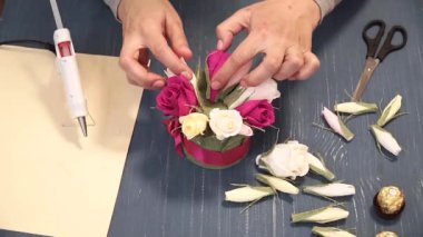 Oluklu kağıt kesmek parlak pembe kadın elinde close-up. Kağıt origami çiçek düğmesinin kadın dekoratör pas geçiyor. Modern Sanat: partiler, Düğünler ve 8 Mart süslemek için kağıt el sanatları yapma