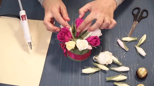 Close-up of corrugated paper hack bright pink in female hands. Female decorator folds of paper origami flower button. Modern art: making crafts out of paper to decorate parties, weddings and march 8 — Stock Video