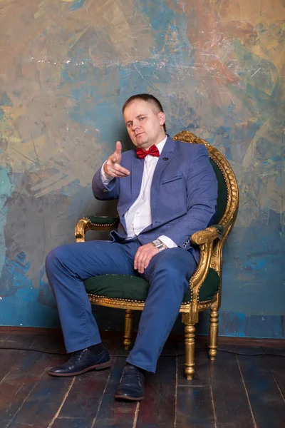 Imponente hombre maduro en traje elegante sentado en una silla de cuero en un moderno interior de lujo. Moda. Negocio. —  Fotos de Stock