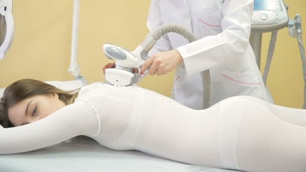 Дівчина в конкретних колготках масажується для зменшення целюліту з системою масажу LPG — стокове відео