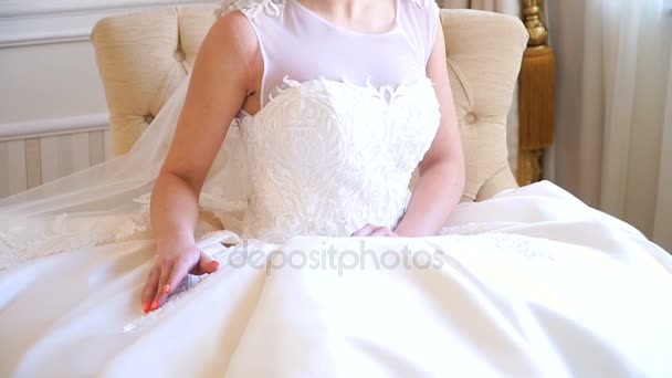 Porträt der schönen jungen Braut. Ein Mädchen posiert in einem Hotelzimmer. Eine Dame sitzt mit einem Rosenstrauß am Fenster. Braut wartet im Hotel — Stockvideo