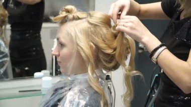 Güzellik Salonu genç bir kadın portresi: muhteşem bir ayar bukleler oluşturma. Kuaför bir sarışın güzel bir saç modeli yapar. Saç Bakımı ve görüntüsü oluşturma.