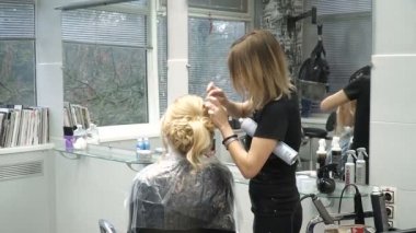 Güzellik Salonu genç bir kadın portresi: muhteşem bir ayar bukleler oluşturma. Kuaför bir sarışın güzel bir saç modeli yapar. Saç Bakımı ve görüntüsü oluşturma.
