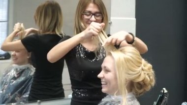 Güzellik Salonu genç bir kadın portresi: muhteşem bir ayar bukleler oluşturma. Kuaför bir sarışın güzel bir saç modeli yapar. Saç Bakımı ve görüntüsü oluşturma.