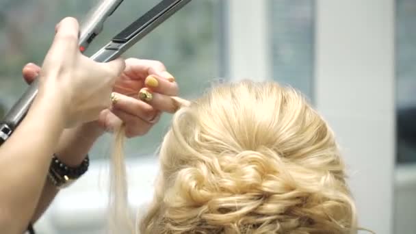 Retrato de uma jovem mulher em um salão de beleza: criando um cenário magnífico de cachos. Uma loira em um cabeleireiro faz um belo penteado. Cuidados com o cabelo e criar uma imagem . — Vídeo de Stock