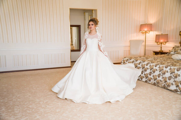 Портрет красивой молодой невесты. Девушка позирует в номере отеля. Дама стоит у окна. невеста ждет в отеле
.