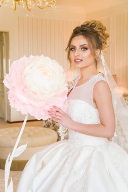 Güzel genç gelin portresi. Bir kız bir otel odasında poz. Bir bayan bir kağıt çiçek pencerenin kenarında oturuyor. Otelin bekliyor gelin