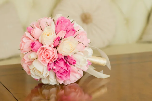 Un bouquet de roses en papier se trouve sur une table en bois dans la chambre d'hôtel — Photo