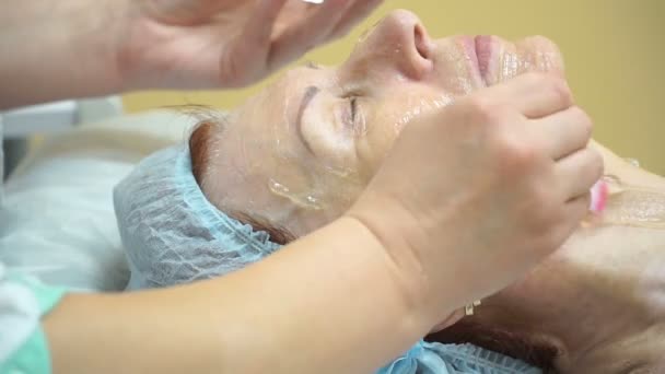 Yaşlı bir kadın hazırlanması için Rf yordamı bir kozmetik kliniğinde kaldırma. Yüze jel uygulama. — Stok video