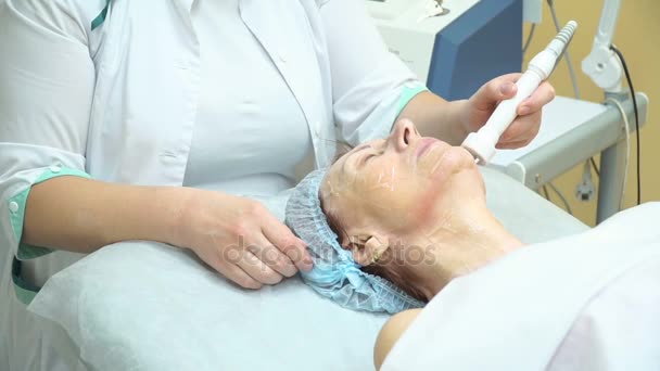 Une femme âgée subit la procédure de levage RF dans une clinique de cosmétologie . — Video