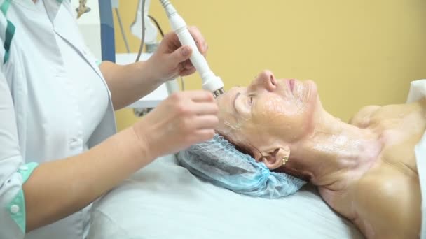 An elderly woman undergoes the RF lifting procedure in a cosmetology clinic. — Stock Video