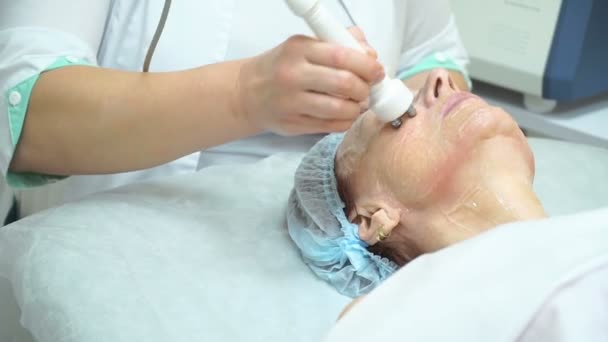 Μια ηλικιωμένη γυναίκα υποβάλλεται σε Rf άρση διαδικασία σε μια κλινική κοσμετολογία. — Αρχείο Βίντεο