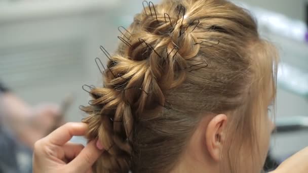 Portrait d'une jeune femme dans un salon de beauté : créer un cadre magnifique à partir de boucles. Une blonde dans un coiffeur fait une belle coiffure. Soins capillaires et création d'une image . — Video