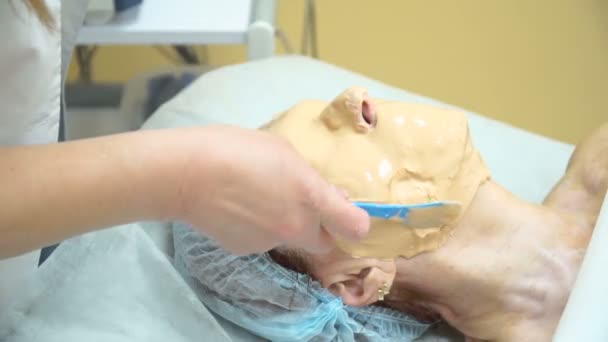 Yaşlı bir kadın bir maske Rf yordamı bir kozmetik kliniğinde kaldırma sonra verilir. — Stok video