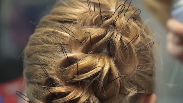 Portrait of a young woman in a beauty salon: creating a magnificent setting from curls. A blonde in a hairdresser does a beautiful hairstyle. Hair care and creating an image. — Stock Video