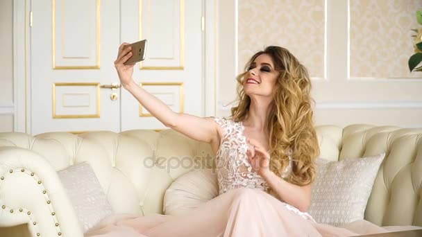 Selfie、手の女性で携帯電話をしている美しい金髪の花嫁写真を取る、近代的な技術により、通信距離は、selfie の写真をソーシャル ネットワークと instagramma を行う若い女性に — ストック動画
