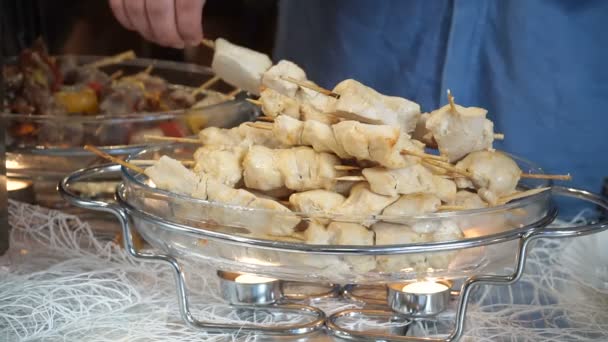 People grabs appetizers from Meat on skewers. — Stock Video