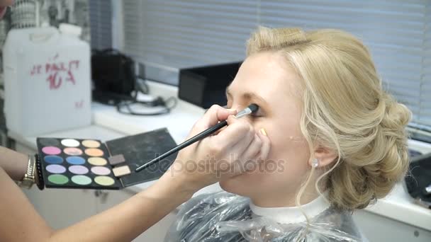 Makeup artist rende una ragazza bella trucco prima di un evento importante — Video Stock